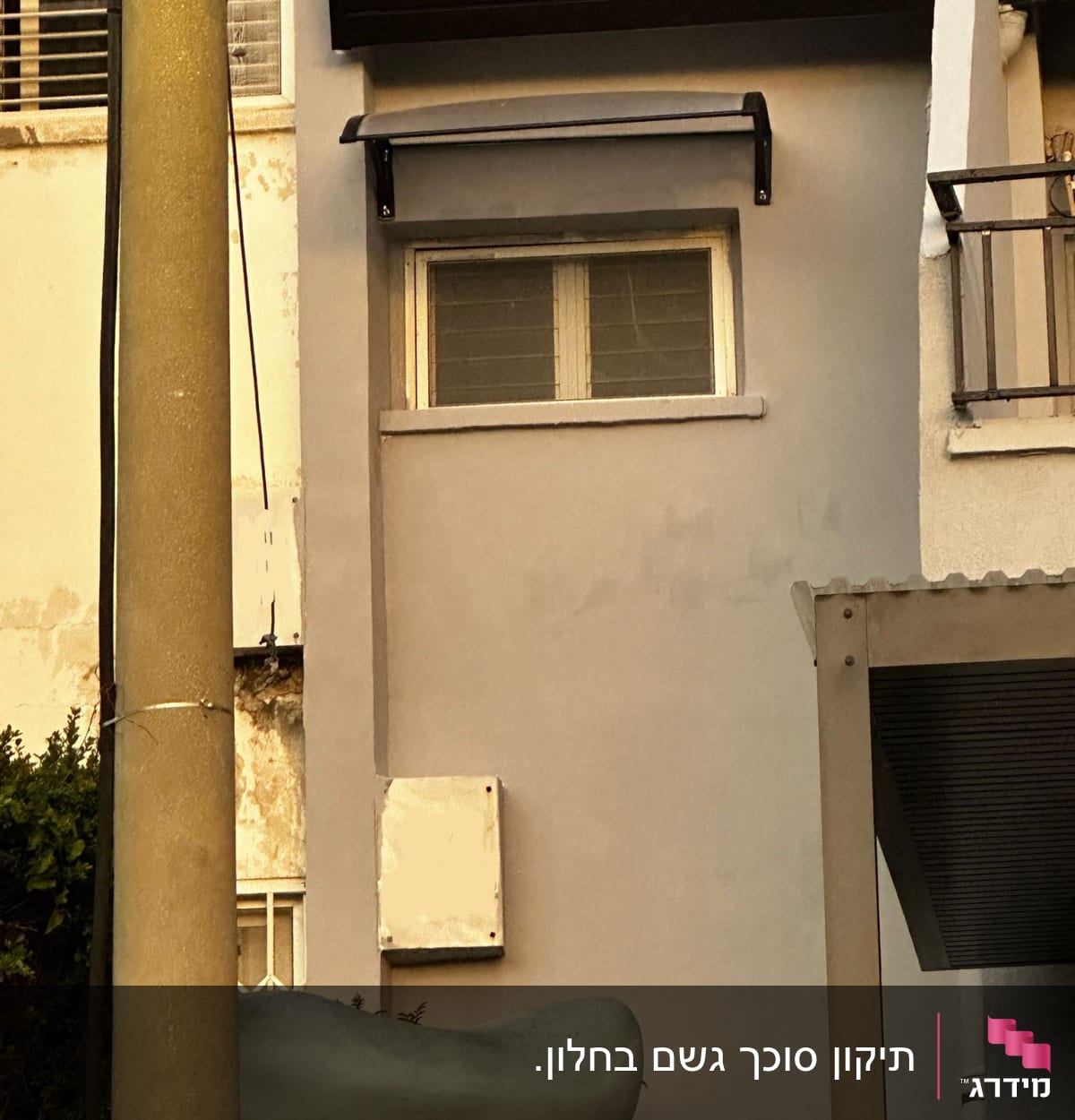 קיר חיצוני עם חלון וסוכך מתכת